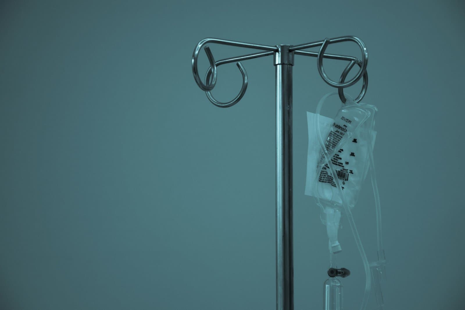 Dråbestativ med intravenøs væskepose hængende på hospitalsstue